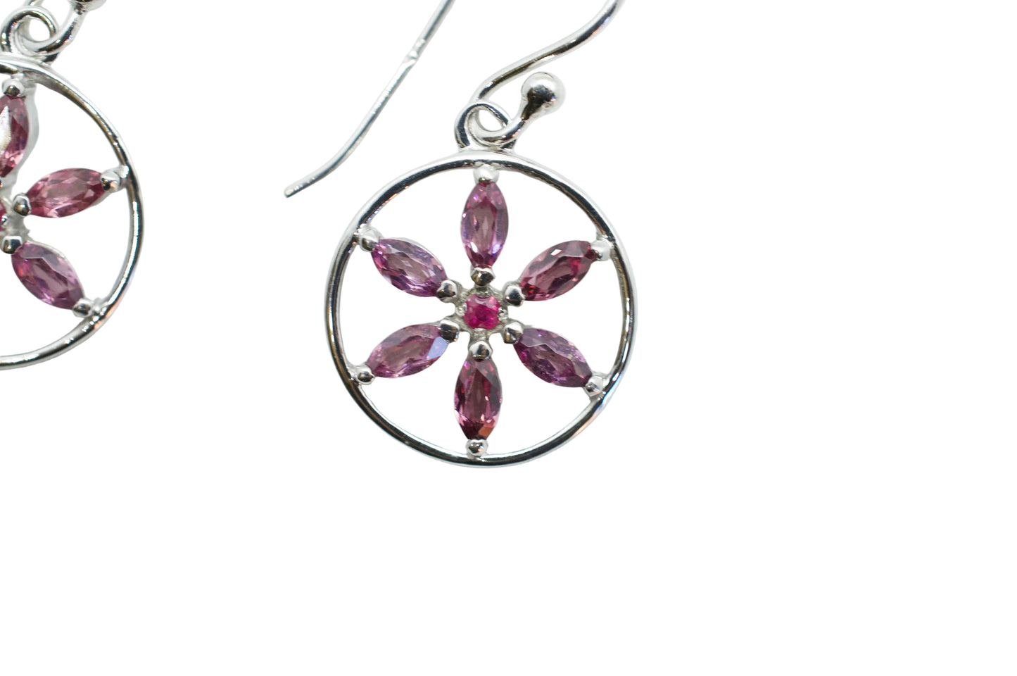 Silver earrings with pink gemstones on a white background