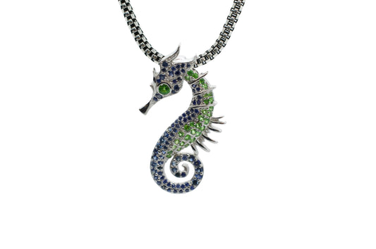 Seahorse-shaped necklace with gemstones on a light gray background