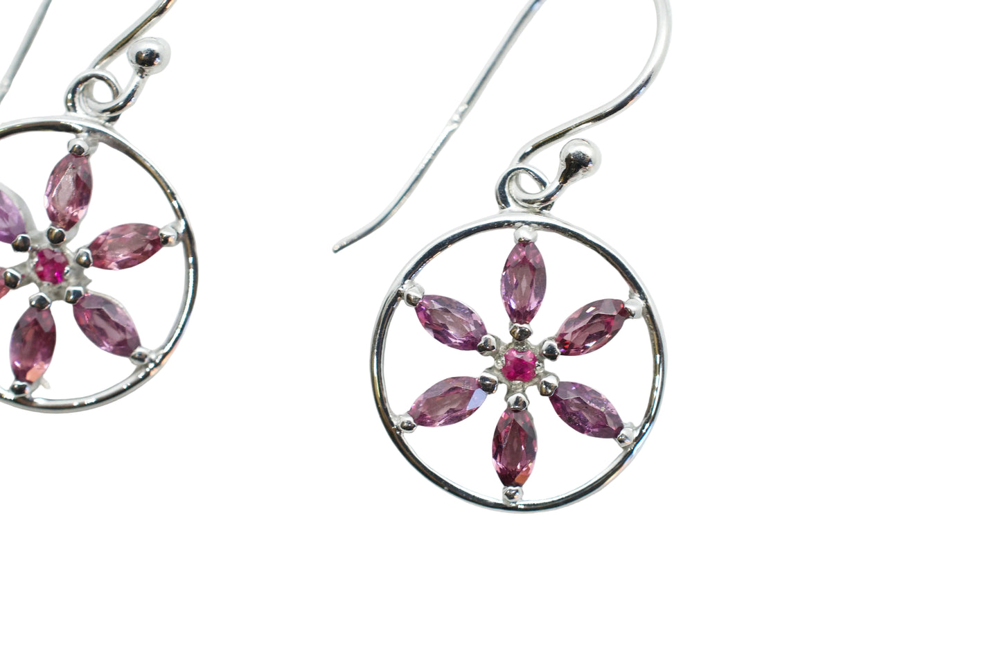 Silver earrings with pink gemstones on a white background