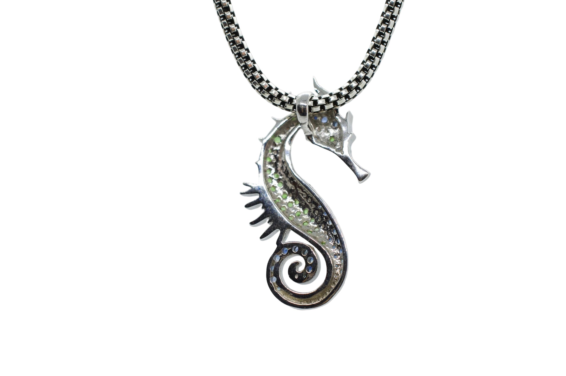 Silver seahorse pendant on a chain against a light gray background