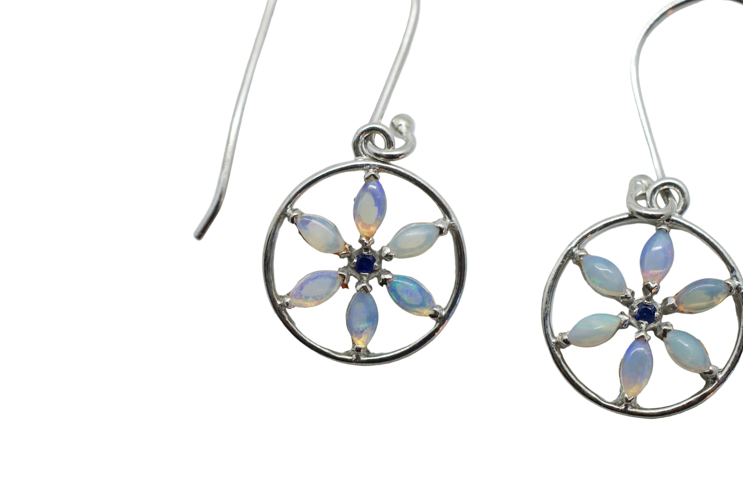 Silver earrings with circular designs and opal-like stones on a light gray background