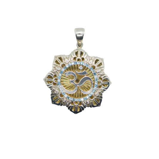 A silver and gold-plated pendant featuring blue sapphires and a design with the spiritual symbol 'Om' in the center.