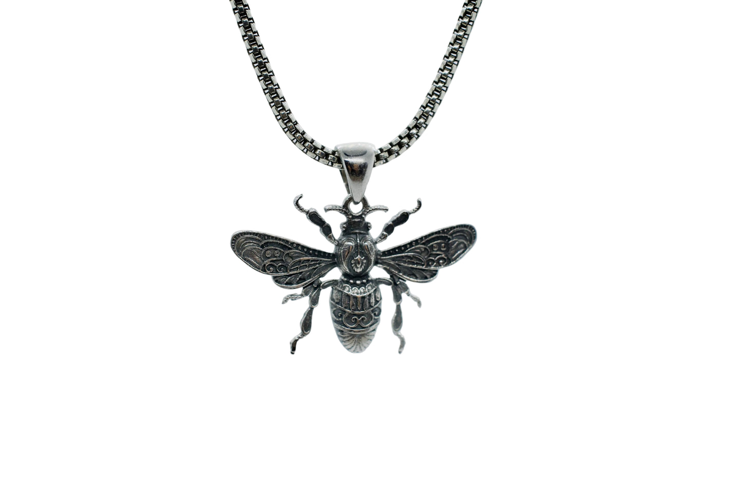 Silver bee pendant on a chain against a light gray background