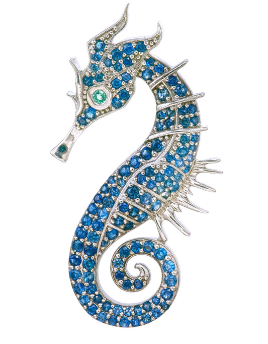 Jeweled seahorse brooch with blue stones on a white background