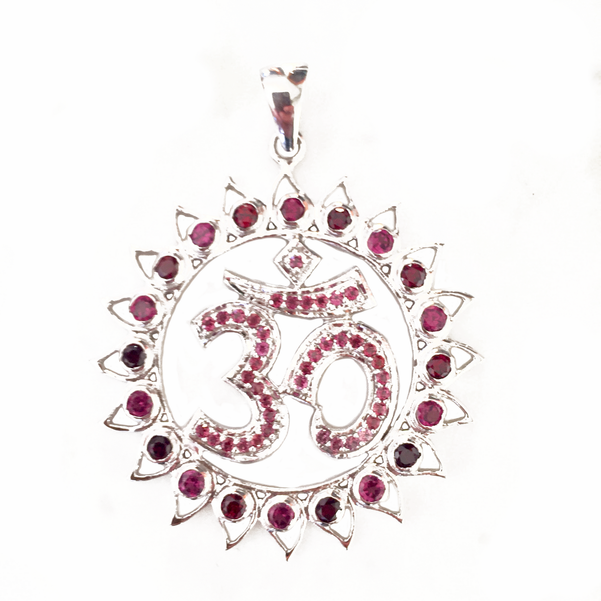 A sterling silver pendant featuring a lotus flower design with a central om symbol, surrounded by garnet and pink tourmaline stones.