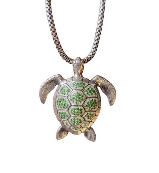 A sterling silver necklace featuring a pendant in the shape of a green sea turtle with tsavorite gemstones.