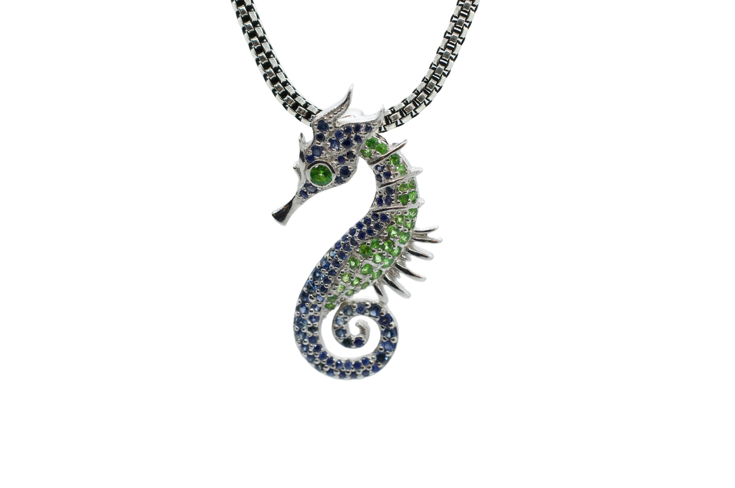 Seahorse-shaped necklace with gemstones on a light gray background