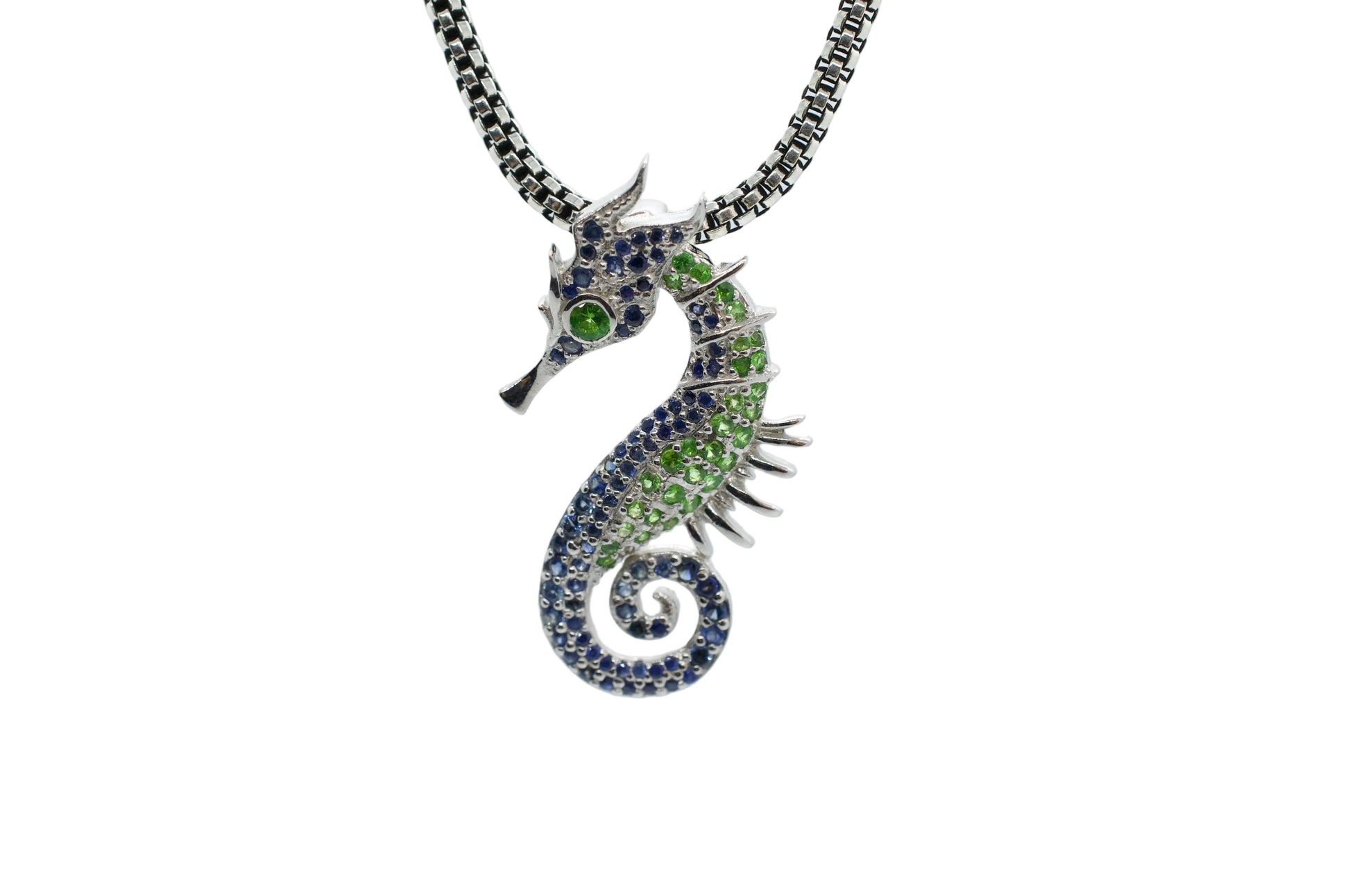 Seahorse-shaped necklace with gemstones on a light gray background